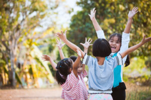 Asian children raise hands and playing together with fun in the park